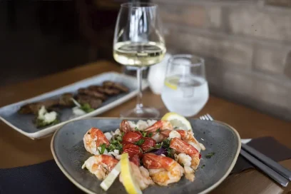 Succulent shrimp paired with a refreshing glass of white wine, perfect for a delightful dining experience at Inco Turkish Restaurant & Fish Bar, London.